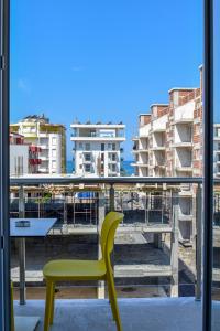 a yellow chair sitting on top of a balcony at Gimi Apartments Shengjin in Shëngjin