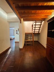 un salon avec un escalier et une chambre avec un lit dans l'établissement Casa Clemente Lachigoló, à San Francisco Lachigoló