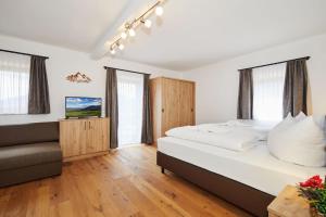 ein Schlafzimmer mit einem großen Bett und einem Sofa in der Unterkunft Gasthaus Ulrichshögl in Ainring