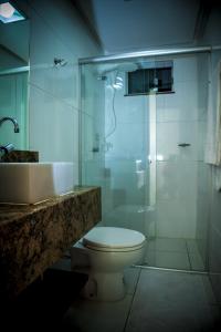a bathroom with a toilet and a shower and a sink at Executivo Flat 1 in Parauapebas