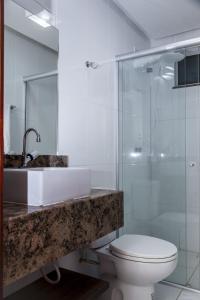 a bathroom with a sink and a toilet and a shower at Executivo Flat 1 in Parauapebas