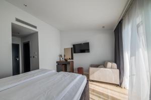 a bedroom with a bed and a couch and a television at Marello in Promajna