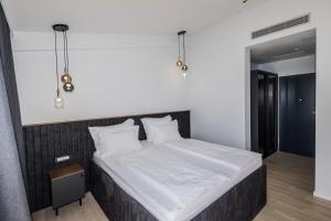 1 dormitorio con 1 cama grande con sábanas y almohadas blancas en Marello en Promajna