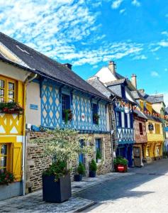 a row of blue and yellow houses on a street at JOSSELIN CHURCH VIEW . in Josselin