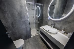 ein Badezimmer mit einem Waschbecken, einem WC und einem Spiegel in der Unterkunft Marello in Promajna