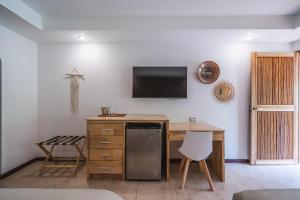 a kitchen with a desk and a tv on a wall at Hotel Arco Iris in Tamarindo