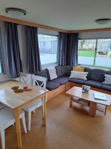 een woonkamer met een bank en een tafel bij Stacaravan 169 5* camping De kuilart in Friesland in Koudum