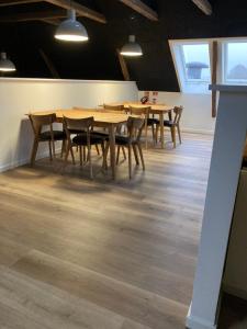 une salle à manger avec des tables et des chaises en bois dans l'établissement Signinn, à Varde