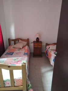 1 dormitorio con 2 camas y mesa con lámpara en Mendoza de sol en Villa Nueva