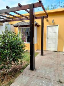 una pérgola sobre la entrada de una casa en Mendoza de sol en Villa Nueva