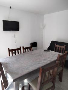 a dining room with a table and chairs and a television at Mendoza de sol in Villa Nueva