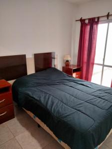 Un dormitorio con una cama con una manta azul. en Mendoza de sol en Villa Nueva