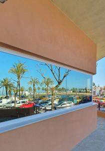 een uitzicht op auto's op een parkeerplaats door een raam bij Playa Doñana 1 in Sanlúcar de Barrameda