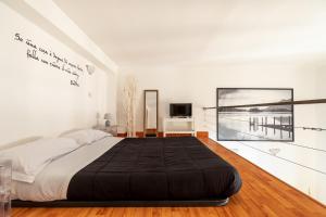 ローマにあるGinevra Suiteの白い部屋に大型ベッド1台が備わるベッドルーム1室が備わります。