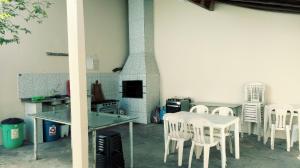 une salle à manger avec des chaises blanches, une table et une cheminée dans l'établissement Parque Mãe Bonifácia-Sobrado 4 suítes com ar e piscina, à Cuiabá