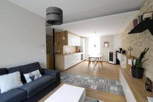 ein Wohnzimmer mit einem blauen Sofa und einer Küche in der Unterkunft - Résidence Martimprey ! - in Nancy