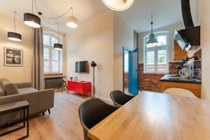 a living room with a wooden table and chairs at Apartament Foto Loft - Villa Vinci - Z prywatnym monitorowanym parkingiem - Space Apart in Jelenia Góra