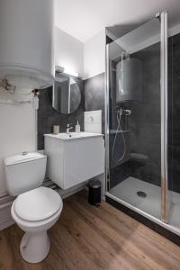 a white bathroom with a toilet and a shower at Joli studio avec vue panoramique sur la Mer in Houlgate