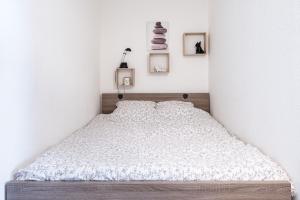 a bedroom with a white bed with two pictures on the wall at Joli studio avec vue panoramique sur la Mer in Houlgate