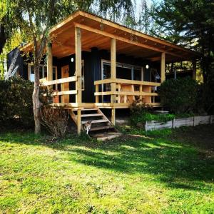 a small house with a porch and a cat standing in front of it at Sector 3 de Camping Angostura in Las Cabras