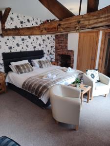 a bedroom with a large bed and two chairs at The Bear in Rhayader