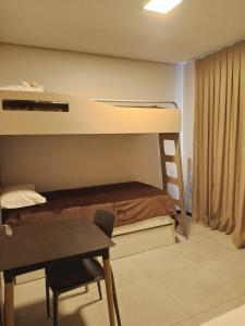 a small room with a bunk bed and a desk at Terraço Flecheiras in Flecheiras