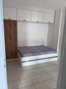Apartamento em Amaralina في سلفادور: غرفة صغيرة مع سرير صغير في غرفة
