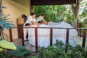 Eine Frau auf einem Bett mit zwei Männern in der Unterkunft Plaza Pelicanos Club Beach Resort All Inclusive in Puerto Vallarta