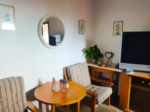 un soggiorno con un tavolo e una televisione di Panoramablick Hohenrode a Sasbachwalden Altre 9 foto