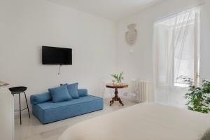 a living room with a blue couch and a tv at Palazzo Ventimiglia Lodge & Suites in Palermo