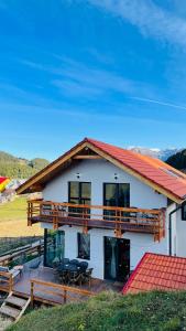 una gran casa blanca con techo rojo en Casa de sub Munte Fundata2, en Fundata 25 fotos más