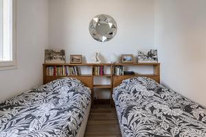 ウルガットにあるCharmant appartement face à la Mer avec balconのベッドルーム1室(ベッド1台、壁掛け鏡付)
