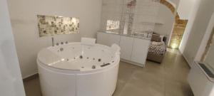 a large white bath tub in a room at Casa Zummo Ortigia Luxury Apartment in Siracusa
