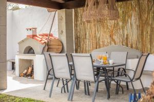 a table and chairs on a patio with a fireplace at Hriska Luxury Villa in Ixia