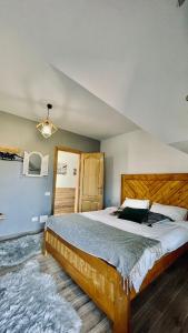 a bedroom with a large bed with a wooden headboard at Casa de sub Munte Fundata2 in Fundata