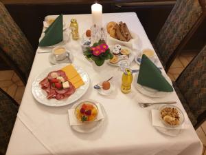 une table blanche avec des assiettes de nourriture dans l'établissement Gasthof Bad Sonnenberg, à Nüziders