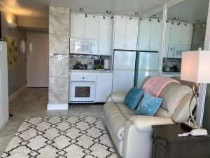a living room with a couch and a kitchen at Beach Blessed - Sea View at Symphony Beach Club in Ormond Beach