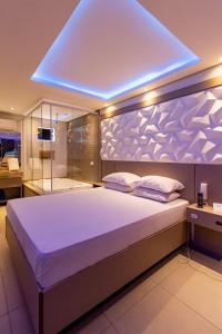 Un dormitorio con una cama grande con una luz azul encima. en Motel Veleiros - Zona Norte en São Paulo