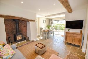 a living room with a fireplace and a table with chairs at The Engine House, 36 Coalford in Ironbridge