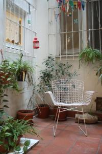 une chaise blanche assise sur une terrasse agrémentée de plantes dans l'établissement Sa Prazza GuestHouse, à Cagliari