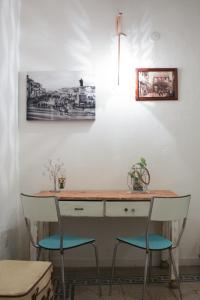 a desk with two chairs next to a wall at Sa Prazza GuestHouse in Cagliari