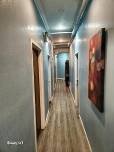 a long hallway with blue walls and wooden floors at European Hostel in San Francisco