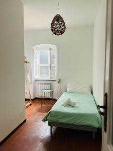 sypialnia z zielonym łóżkiem i stołem w obiekcie AceroRosso Farmhouse w mieście Sarzana