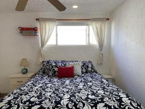 a bedroom with a black and white bed with a window at Poco Cielo Hotel in Rosarito