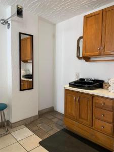 a kitchen with wooden cabinets and a counter top at Poco Cielo Hotel in Rosarito