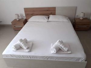 a large white bed with two white towels on it at Апартамент Quattro in Dobrich +4 photos