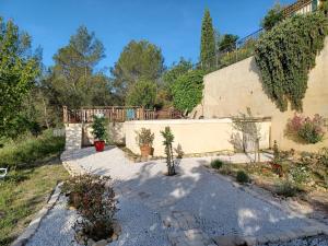 einen Hinterhof eines Hauses mit einem Zaun und Pflanzen in der Unterkunft Une chambre en Provence in Correns