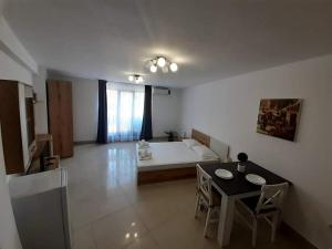a living room with a bed and a table and chairs at Апартамент Quattro in Dobrich