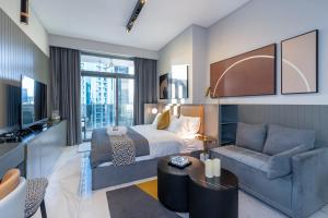 a hotel room with a bed and a couch at Lux Studio in Downtown, 5 mins to Burj Khalifa & Dubai Mall - MAG318 in Dubai