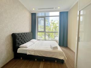 a bedroom with a bed with a large window at Landmark - Homes by Christine in Ho Chi Minh City